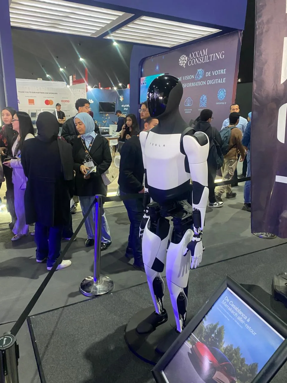 Tesla Optimus robot drawing crowds at GITEX Africa 2026 — view from behind